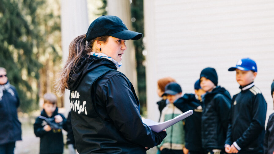 Pikkuprovinssin ohjaaja opastaa taka-alalla olevia lapsia.